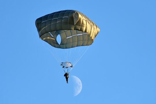 A U.S. Army paratrooper descends onto Juliet Drop Zone, Pordenone, Italy, after exiting an Air Force C-130 Hercules aircraft during airborne operations, Dec. 3, 2019. (Paolo Bovo/Army)
