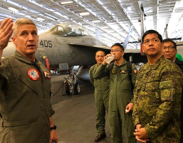 Rear Adm. Steve Koehler, left, commander CSG-9 of the U.S. aircraft carrier Theodore Roosevelt, briefs top Philippine generals led by Lt. Gen. Rolando Joselito Bautista, foreground right, Tuesday, April 10,2018, in international waters off South China Sea. The aircraft carrier CVN-71 is sailing through the disputed South China Sea in the latest display of America's military might after China built a string of islands with military facilities in the strategic sea it claims almost in its entirety. (Jim Gomez/AP)