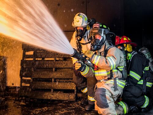Senior Airman Daniel Kolk, 436th Civil Engineer Squadron driver operator, extinguishes flames in a controlled exercise at the structural burn training facility April 26, 2019, at Dover Air Force Base, Del. (Senior Airman Christopher Quail/Air Force)