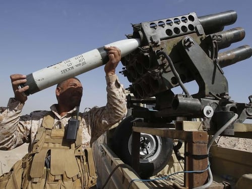 A Shiite Iraqi fighter, loyal to Grand Ayatollah Ali al-Sistani, loads a missile launcher during clashes with Islamic State militant group fighters in Jurf al-Sakher, north of the Shiite shrine city of Karbala on October 19, 2014. (MOHAMMED SAWAF/AFP/Getty Images)