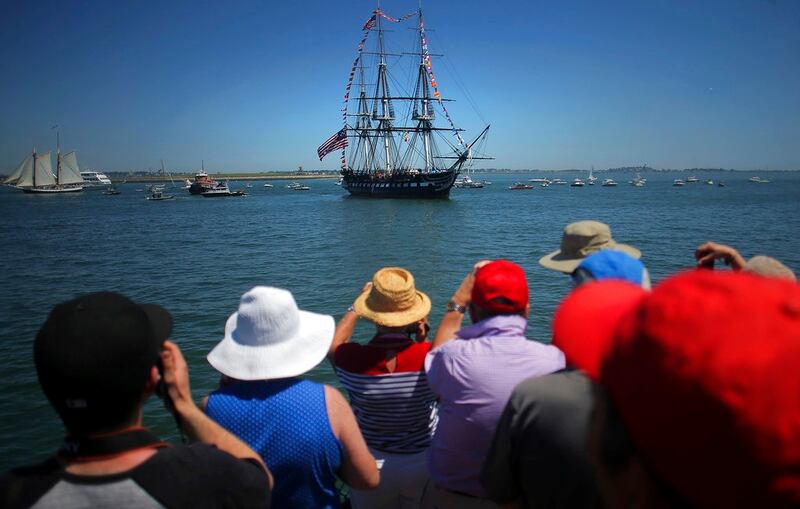A crowd gathers to view the USS Constitution in Boston on Wednesday, July 4, 2018. The world's oldest commissioned warship still afloat left its berth at the Charlestown Navy Yard Wednesday morning and glided through the harbor to mark 242 years since the signing of the Declaration of Independence. The ship nicknamed 