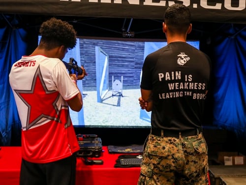 U.S. Marine Corps Sgt. Peter Lopez, a recruiter with the 8th Marine Corps District, oversees a spectator operating the marksmanship trainer during Ultimatum II, a Smash Ultimate Tournament hosted by Esports Stadium Arlington, in Arlington, Texas, December 27, 2019. (Cpl. Desmond Andrews/Marine Corps)