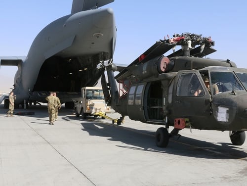 Aerial porters work with maintainers to load a UH-60L Black Hawk helicopter into a C-17 Globemaster III in support of the Resolute Support retrograde mission in Afghanistan, June 16, 2021. (Sgt. 1st Class Corey Vandiver/Army)