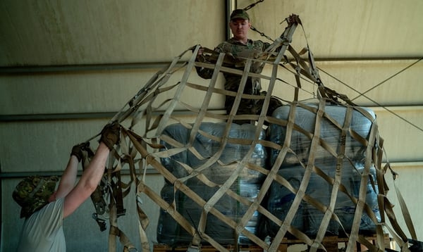 Air Force Master Sgt. John Schmit, left, with the 435th Contingency Response Group at Ramstein Air Base, Germany, and Staï¬ Sgt. Brandon Deal, 75th Expeditionary Airlift Squadron, build pallets of humanitarian aid in Maputo, Mozambique, April 4. (Tech. Sgt. Thomas Grimes/Air Force)