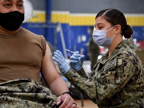 Hospital Corpsman 2nd Class Angelina Mangram administers the COVID-19 vaccine at the Naval Base San Diego fitness center on Jan. 6, 2021. (MC1 Julio Rivera/Navy)