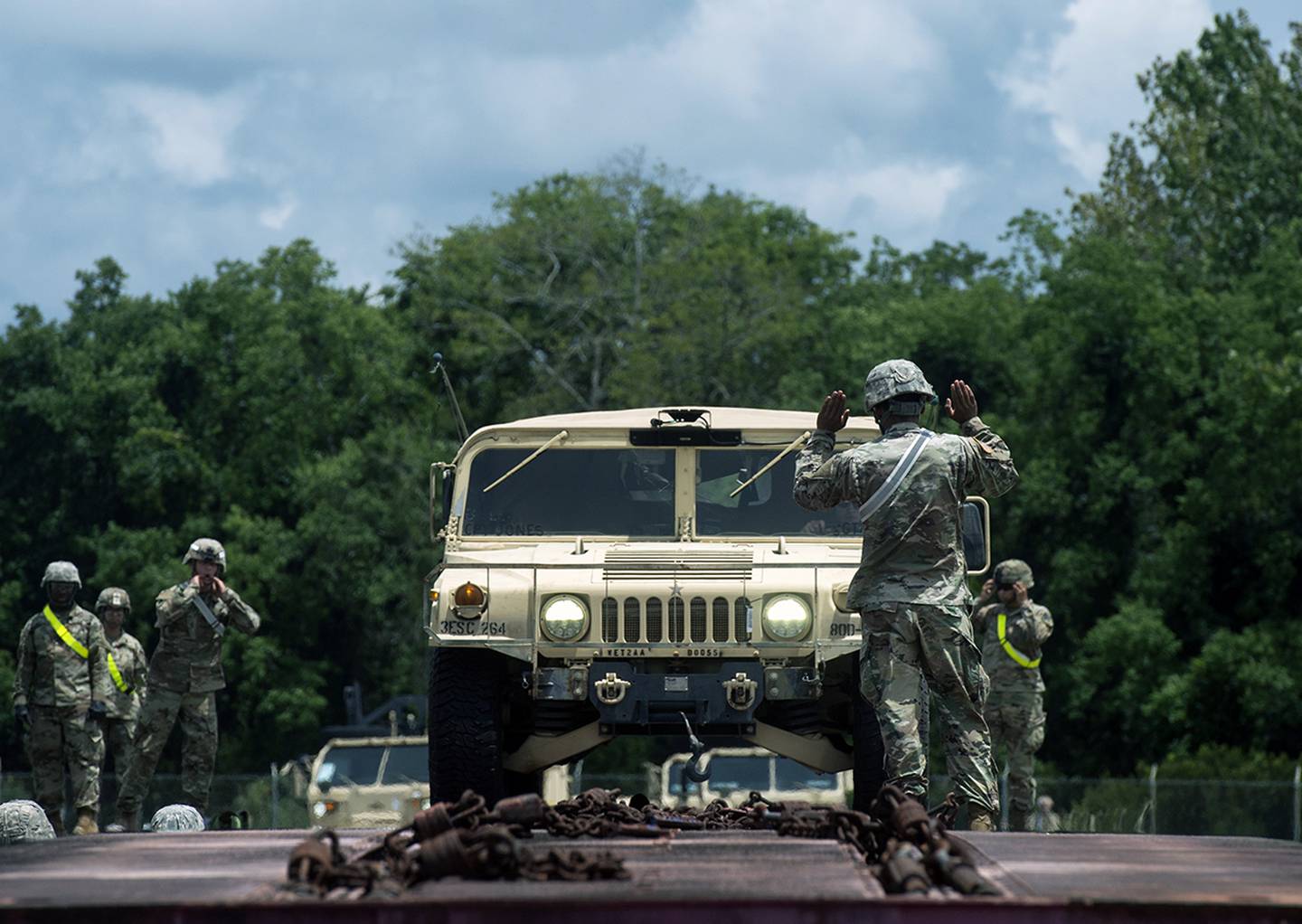Soldiers guide a Humvee driver during rail operations as part of exercise Dragon Lifeline on July 31, 2018, at Joint Base Charleston’s Naval Weapon Station, S.C.