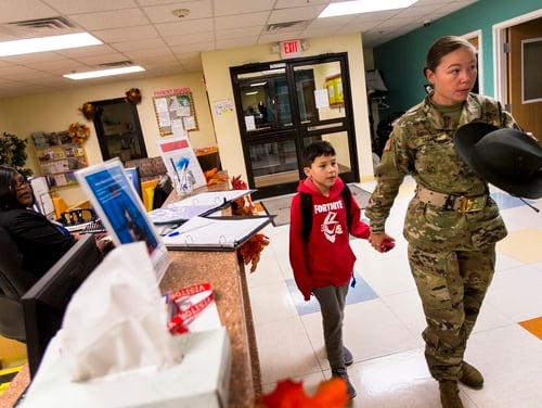 Dennie Taylor, a drill sergeant with the U.S. Army, signs in her son Ethan at the Imboden Child Development Center at Fort Jackson, S.C., on Nov. 19, 2019. (Andrew J. Whitaker/The Post And Courier via AP)