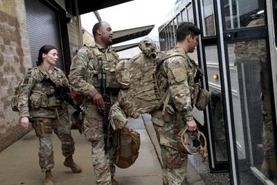 In this Jan. 4, 2020, file photo, U.S. Army soldiers with their gear board an awaiting bus at Fort Bragg, N.C., as troops from the 82nd Airborne are deployed to the Middle East.