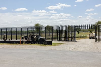 Members of the Texas National Guard set up a shade structure while they guard a gate along the border wall in Del Rio on September 16, 2021.