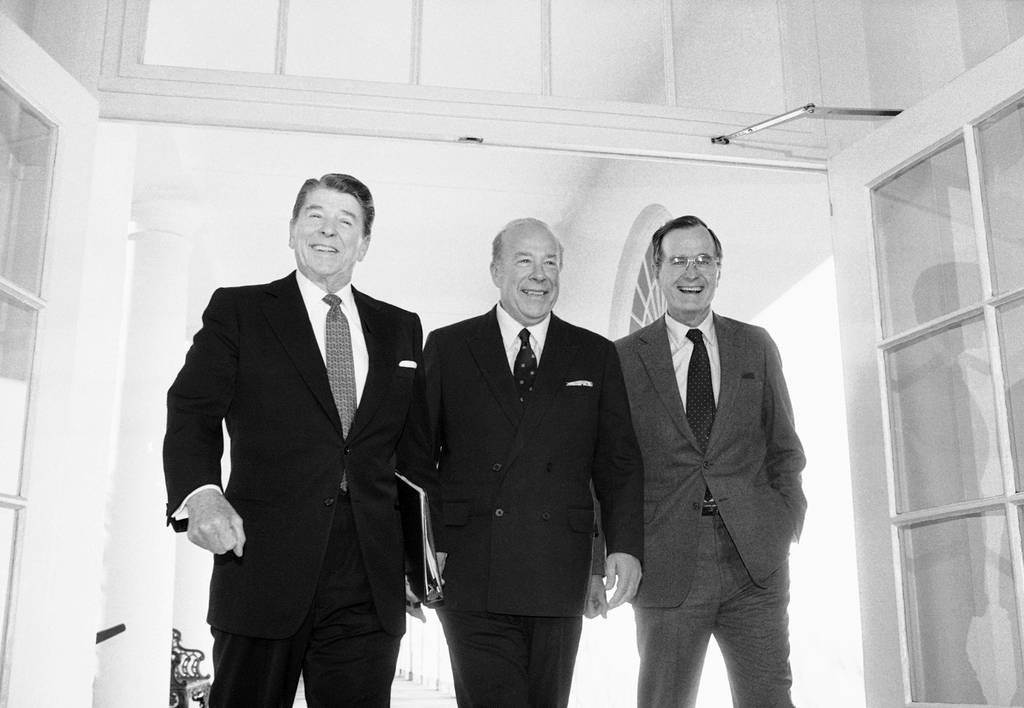 In this Jan. 9, 1985 file photo, Secretary of State George Shultz, center, walks with President Ronald Reagan and Vice President George Bush upon his arrival at the White House in Washington, after two days of arms talks with the Soviet Union in Geneva.