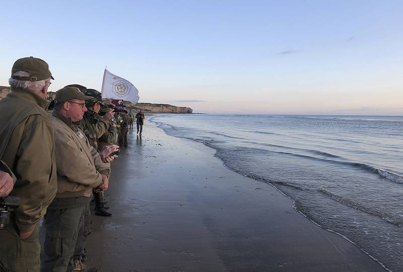 Re-enactors stand at the shore of Omaha Beach at sunrise as part of events to mark the 75th anniversary of D-Day on Omaha Beach in Vierville-sur-Mer, Normandy, France