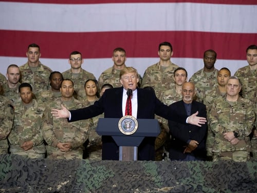 President Donald Trump, center, with Afghan President Ashraf Ghani and Joint Chiefs Chairman Gen. Mark Milley, behind him at right, while addressing members of the military during a surprise Thanksgiving Day visit, Thursday, Nov. 28, 2019, at Bagram Air Field, Afghanistan. (Alex Brandon/AP)