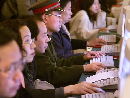 BEIJING, CHINA: Lit up by their computers' blue screens, delegates from across China follow the proceedings, check additional information and send e-mails during the opening session of the National People's Congress (NPC) at the Great Hall of the People in Beijing 05 March 2000. Premier Zhu Rongji issued an unusually strong warning to leading government and Communist Party officials on corruption, saying the battle against graft should be waged at the highest level. Zhu also said China would 
