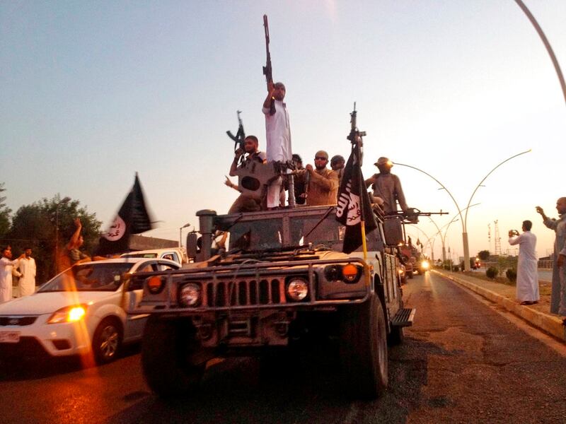 In this June 23, 2014, photo, fighters from the Islamic State group parade in a commandeered Iraqi security forces armored vehicle on the main road in Mosul, Iraq. (AP)