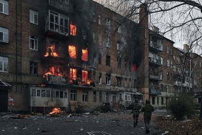 Ukrainian soldiers run to help people in an apartment building on fire after Russian shelling in Bakhmut, Donetsk region, Ukraine, Wednesday, Dec. 7, 2022.
