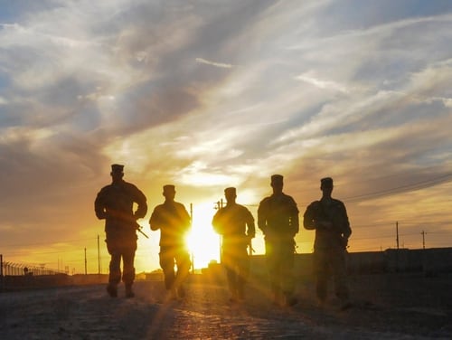 A group of U.S. soldiers walks along the road at sunset in Taji, Iraq, in March 2016. Pentagon officials issued new guidance this week for how to handle discharge upgrades for individuals who may have been dismissed because of undiagnosed medical issues. (Staff Sgt. Victor Joecks/Army National Guard)