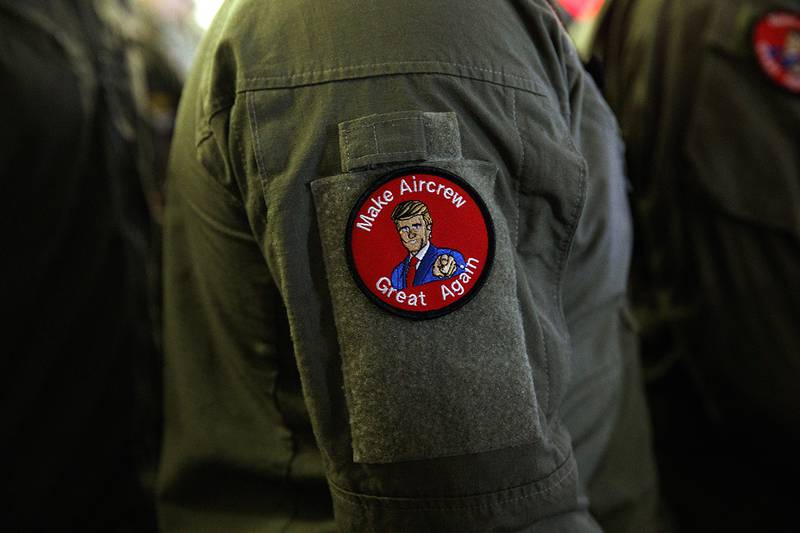 A service member wears a patch that says "Make Aircrew Great Again" as they listen to President Donald Trump speak to troops at a Memorial Day event aboard the USS Wasp on May 28, 2019, in Yokosuka, Japan.