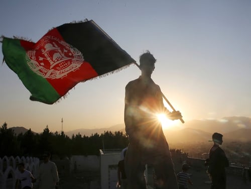 In this Aug. 19, 2019, file photo, a man waves an Afghan national flag during Independence Day celebrations in Kabul, Afghanistan. (Rafiq Maqbool/AP)