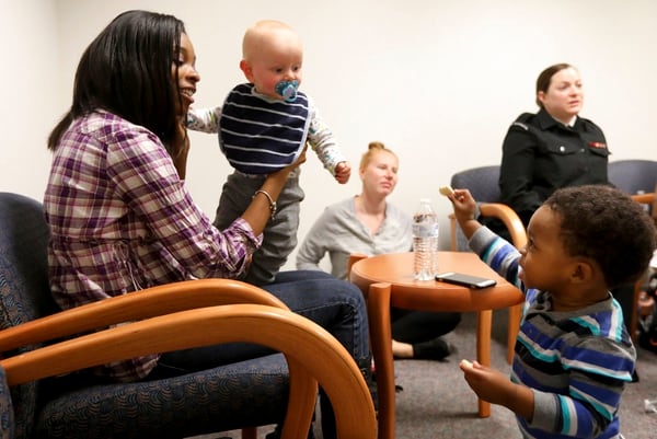 Shauna Hibbler-Cooley holds Travis Beer and talks to her own son Nathan, right, during a meeting of a postpartum support group at Naval Medical Center Portsmouth in Portsmouth, Va. In the background are Ashley Beer, Travis' mom, and Kayla Disbrow. (Steve Earley/The Virginian-Pilot via AP)