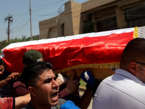 Mourners carry the flag-draped coffin of Hisham al-Hashimi during his funeral, in the Zeyouneh area of Baghdad on July, 7, 2020. Al-Hashimi, an Iraqi analyst who was a leading expert on the Islamic State and other armed groups, was shot dead in Baghdad on Monday. (Khalid Mohammed/AP)