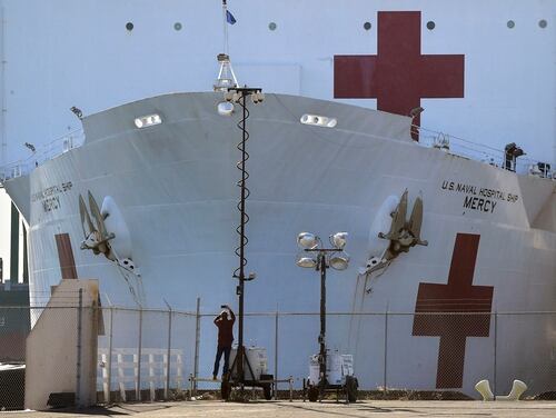 In this March 27, 2020, file photo, a pedestrian takes a picture of the USNS Mercy as it docks at the Port of Los Angeles. (Mark J. Terrill/AP)