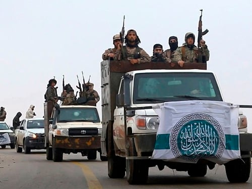 This photo released Dec. 4, 2018, by the al-Qaida-affiliated Ibaa News Agency, shows al-Qaida-linked fighters driving their vehicles during a military drill in northern Syria. (Ibaa News Agency via AP)