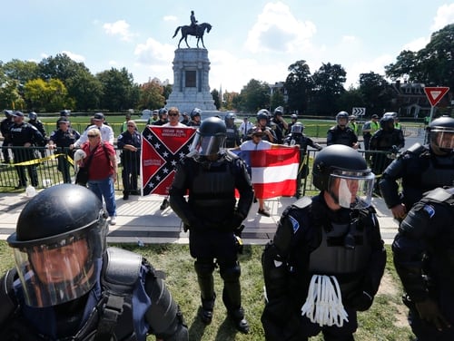 State Police keep a small group of Confederate protesters separated from counter demonstrators in front of the statue of Confederate General Robert E. Lee on Monument Avenue in Richmond, Va. (Steve Helber/AP)