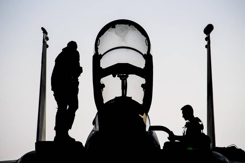 Air Force Capt. Ryan Heil and a maintainer assigned stand on an F-15E Strike Eagle shortly after landing at Al Dhafra Air Base, United Arab Emirates, Feb 13, 2021.
