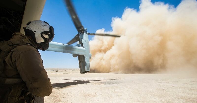 A Marine Corps crew chief observes an MV-22B Osprey land during a resupply mission in support of Combined Joint Task Force – Operation Inherent Resolve at Firebase Um Jorais, Iraq, June 27, 2018. (Cpl. Jered T. Stone/Marine Corps)
