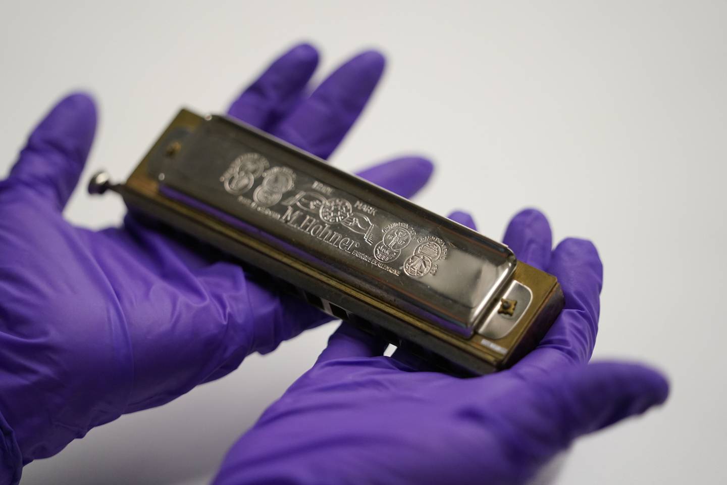 Kim Guise, curator for the National World War II Museum, shows a harmonica used by Wilfred Lyon while a prisoner of the Germans, which will be on display at the new pavilion of the museum, in New Orleans, Friday, Sept. 29, 2023.