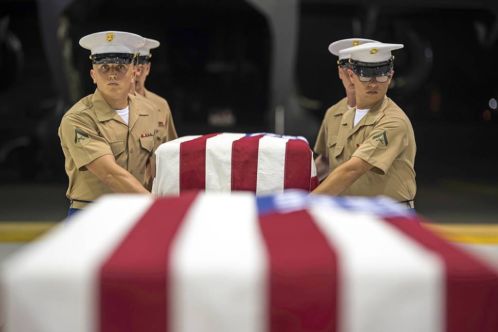 In this Wednesday, July 17, 2019, photo, Marines carry transfer cases holding the possible remains of unidentified service members lost in the Battle of Tarawa during World War II in a hangar at Joint Base Pearl Harbor-Hickam in Hawaii.