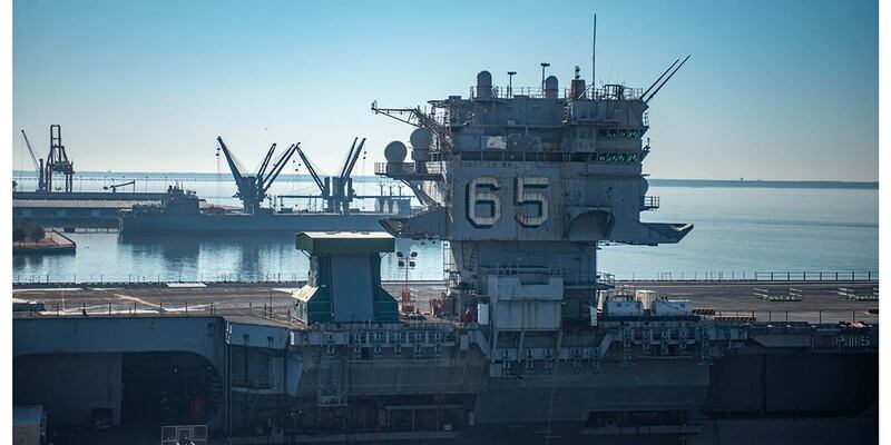 The rusting hulk of the aircraft carrier Enterprise is tied up next to the newest generation of carriers, first-of-class Gerald R. Ford (Mark D. Faram/Staff)