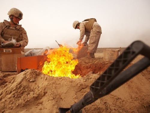 Marines dispose of trash in a burn pit in the Khan Neshin District of Afghanistan in March 2012. (Cpl. Alfred V. Lopez/Marine Corps)