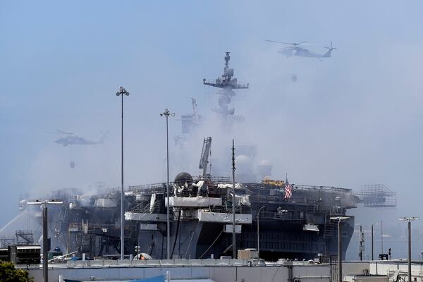 Helicopters approach the U.S. Navy warship Bonhomme Richard as crews fight the fire on July 13, 2020, in San Diego, Calif. (Gregory Bull/AP)