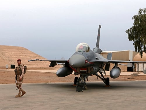 In this Feb. 13, 2018, file photo, an Iraqi army soldier stand guard near a U.S.- made Iraqi Air Force F-16 fighter jet at the Balad Air Base, Iraq. (Khalid Mohammed/AP)