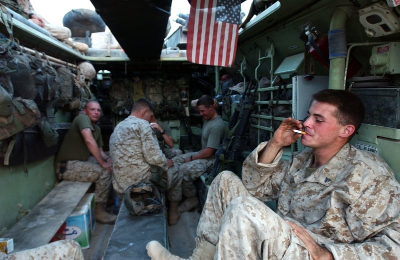 A U.S Marine from the 1st Expeditionary Force, 1st Battalion smokes a cigarette before a possible offensive November 5, 2004, near Fallujah, Iraq. (Marco Di Lauro/Getty Images)