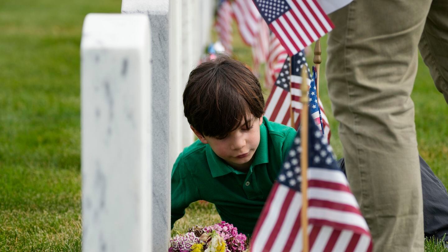 Raphael Michel, 7, of Washington, visits the grave of a soldier, with whom his father served, in Section 60 at Arlington National Cemetery on Memorial Day, May 29. (AP Photo/Alex Brandon)