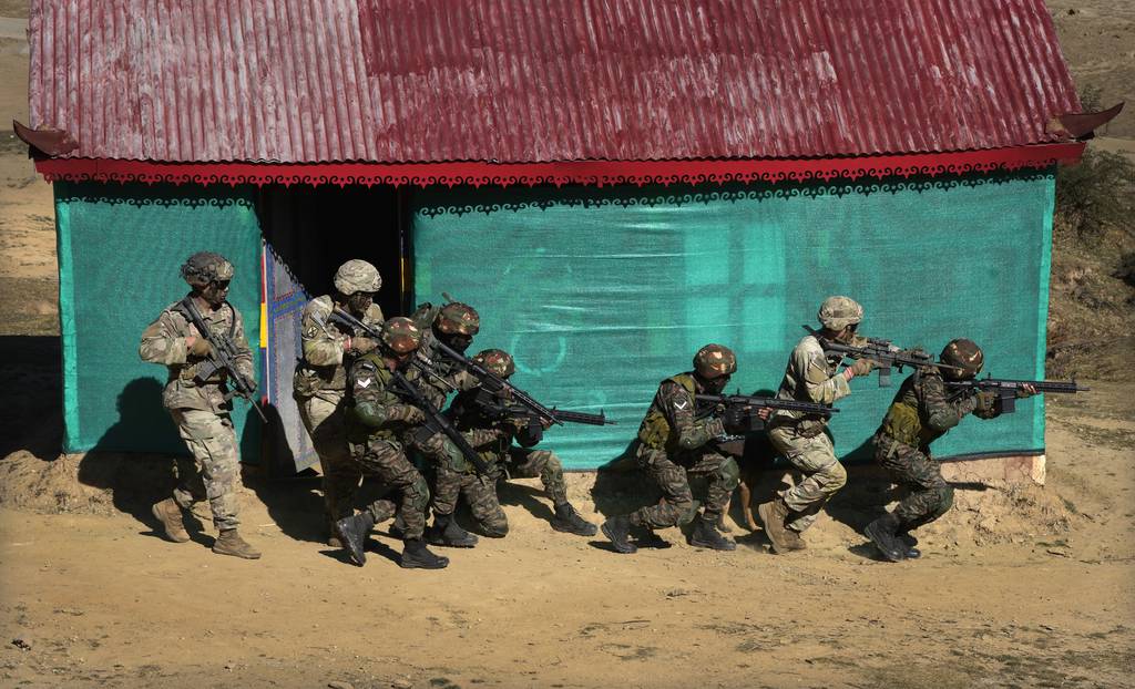 US Army soldiers of 2nd Brigade of the 11th Airborne Division and Indian army soldiers carry out a mock operation to flush out armed gunmen from a house during the Indo-US joint exercise or "Yudh Abhyas," in Auli, in the Indian state of Uttarakhand, Tuesday, Nov. 29, 2022.