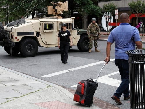 A man walks through an intersection blocked by a military Humvee from D.C. National Guard and a DEA police officer as demonstrators gather to protest the death of George Floyd, Tuesday, June 2, 2020, in Washington. Floyd died after being restrained by Minneapolis police officers. (Jacquelyn Martin/AP)