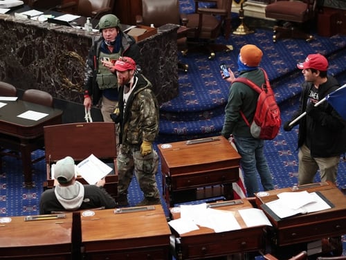 Protesters enter the Senate Chamber on Jan. 06, 2021, in Washington, D.C. The man wearing military body protection and helmet was later identified as Larry Rendall Brock Jr., an Air Force veteran. (Win McNamee/Getty Images)