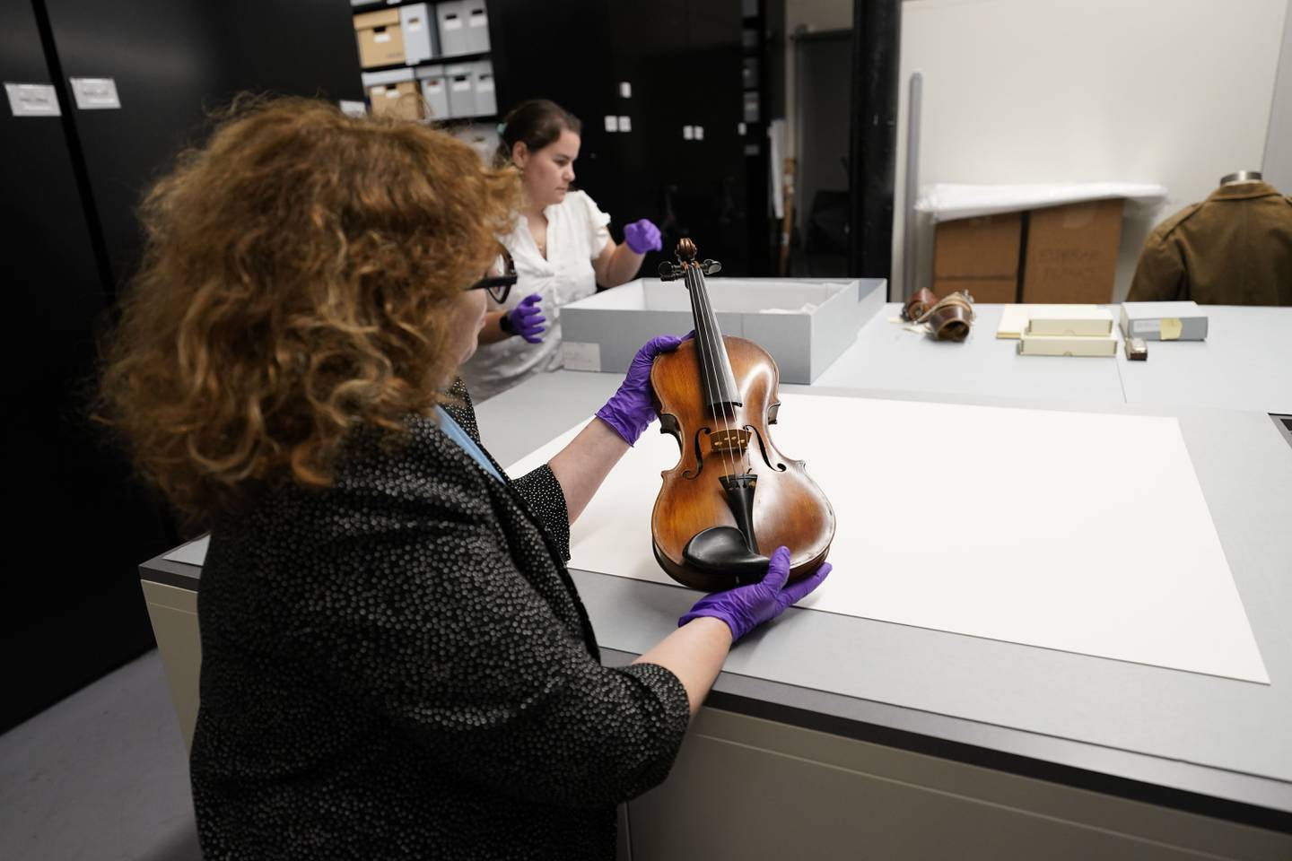 Kim Guise, curator for the National World War II Museum, shows a violin, hand made by Wilfred Lyon while a prisoner of the Germans, which will be on display at the new pavilion of the museum, in New Orleans, Friday, Sept. 29, 2023.