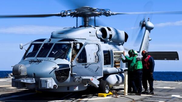 Sailors load sonobuoys onto an MH-60R Sea Hawk helicopter on the flight deck of the Arleigh Burke-class guided-missile destroyer USS Oscar Austin (DDG 79) during flight operations May 10, 2017. (US Navy/Sean Spratt)
