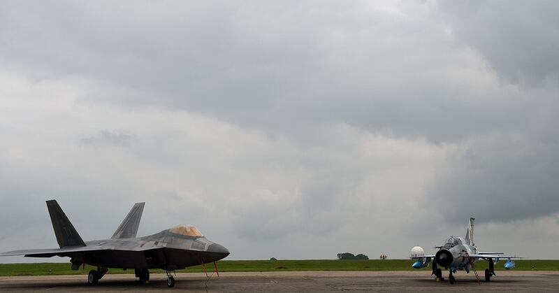 A U.S. Air Force F-22 Raptor, left, is parked next to a Romanian Army MIG 22-Lancer at the Mihail Kogalniceanu air base, near Constanta, Romania, in April 2016. (Daniel Mihailescu/AFP/Getty Images)