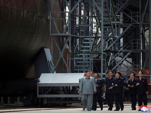 In this undated photo provided on Tuesday, July 23, 2019, North Korean leader Kim Jong Un, left, inspects a newly built submarine to be deployed soon, at an unknown location in North Korea. (Korean Central News Agency/Korea News Service via AP)
