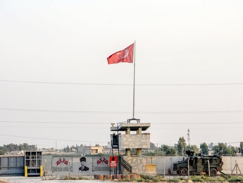 A Turkish military truck patrols next to a Turkish flag hoisted at the border with Syria on Aug. 14, 2019, in Akcakale, in Sanliurfa, southeastern Turkey. (DHA/AFP via Getty Images)