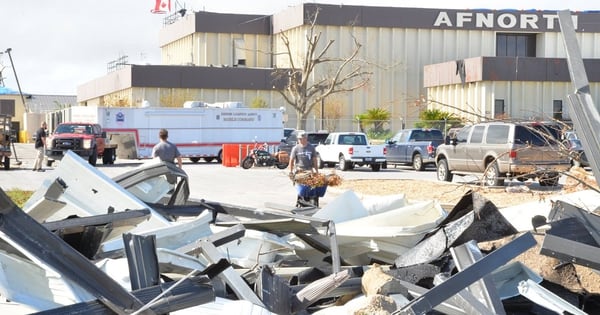 Members of the 601st Air Operations Center clean up debris outside the main building after being hit by Hurricane Michael, a Category 5 storm that ravaged Tyndall Air Force Base, Fla., and the surrounding area. (Maj. Andrew Scott/Air National Guard)