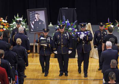 Fargo Police Department Honor Guard members carry a memorial urn and flag at the close of funeral services for Fargo Police Officer Jake Wallin at Pequot Lakes High School in Pequot Lakes, Minn., on Saturday, July 22, 2023
