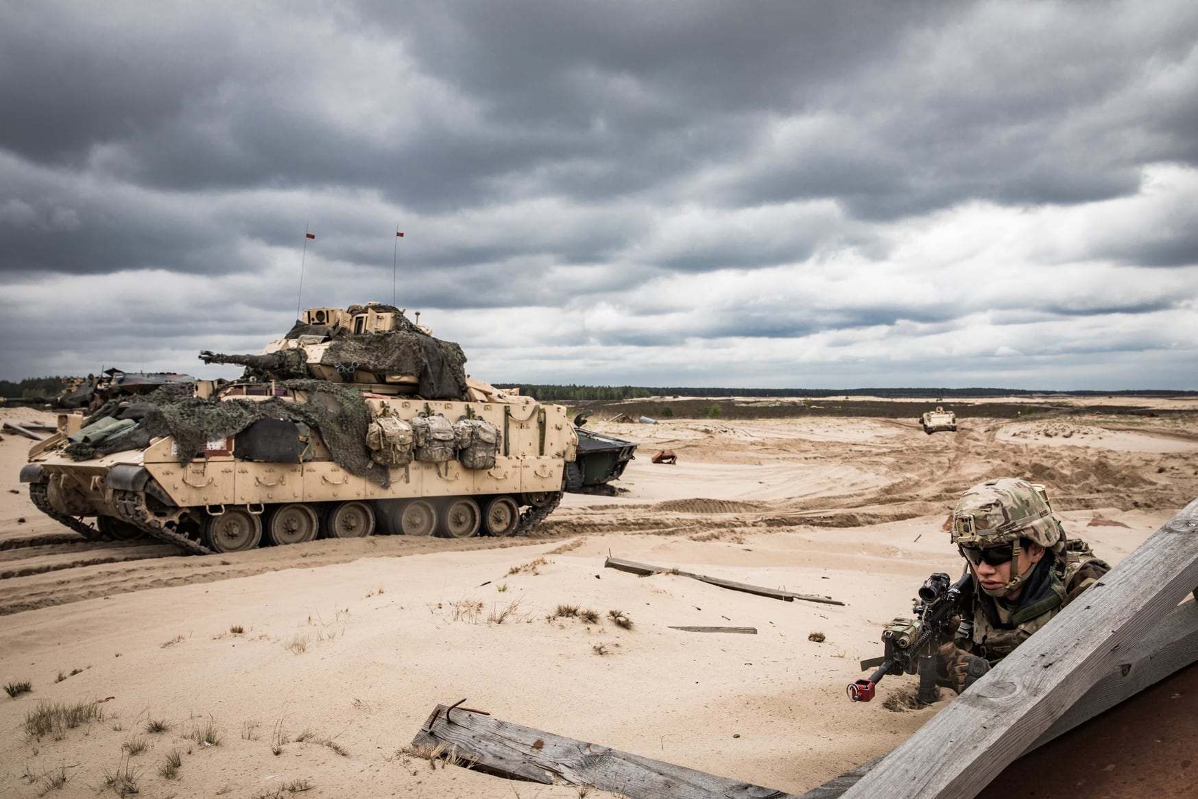 A U.S. Army soldier conducts security next to an M2 Bradley Fighting Vehicle on a range in Trzebień, Poland, during a May 2019 exercise. Soldiers deployed to Poland in support of NATO allies as part of Atlantic Resolve. (Sgt. Jeremiah Woods/U.S. Army)