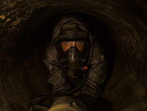 Marine Cpl. Seth White, a chemical, biological, radiological and nuclear defense specialist with the 11th Marine Expeditionary Unit, crawls through an underground tunnel while wearing a Level-C hazmat suit on Camp Pendleton, California, Oct. 3, 2018. (Cpl. Adam Dublinske/Marine Corps)