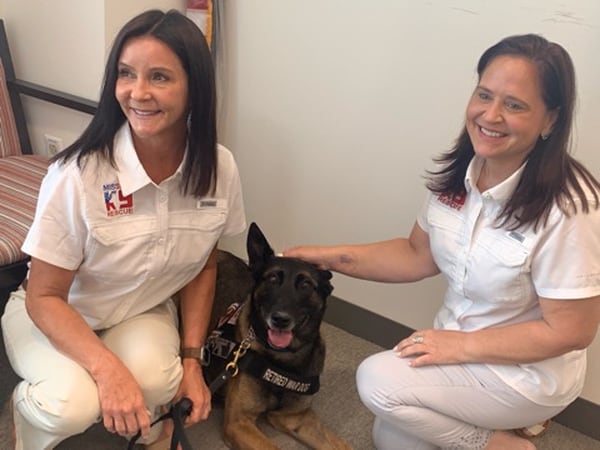 Kristen Maurer (L), president and founder of Mission K9 Rescue, and Louisa Kastner (R), the nonprofit's vice president, pose with Zero, a retired military dog who the organization is helping get adopted. (Joshua Axelrod/Military Times)